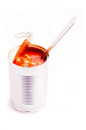 A spoon in a freshly opened can of beansの写真素材