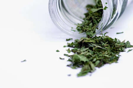 Bottled leafed herbs in a glass containerの写真素材