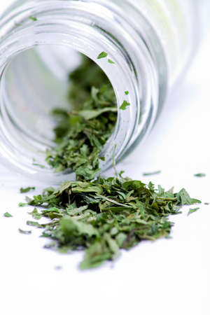 Bottled leafed herbs in a glass containerの写真素材