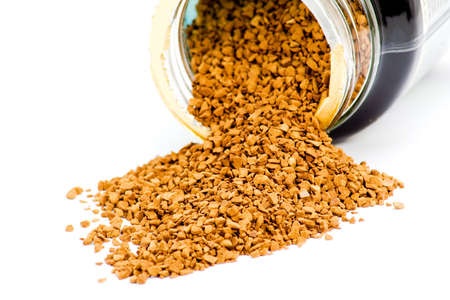 Instant coffee granules spilled from container on whiteの写真素材