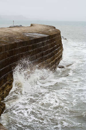 Waves crashing on a sea wall in Lyme Regisの写真素材