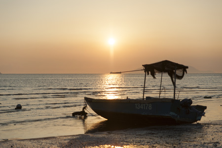 Boat seat on a beach with sunsetの写真素材