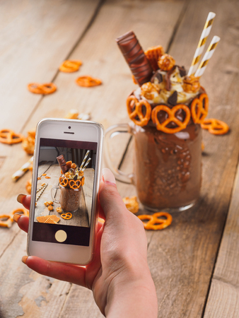Photographing of chocolate freakshake with brezel waffles and popcornの写真素材