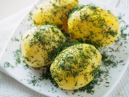 Boiled potato slices wedges with green on the plate.の写真素材