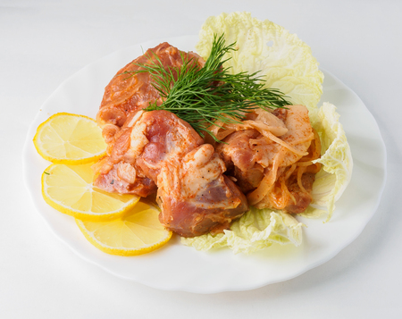 Raw pork beef meat with greens on the white plate.の写真素材