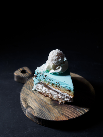 Piece of cake on wooden board. black background.の写真素材