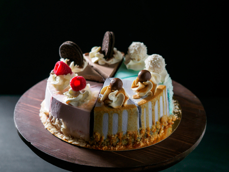 Set of pieces cakes on black background.