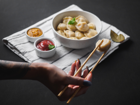 Dumplings on plate at wooden desk on black background.の写真素材