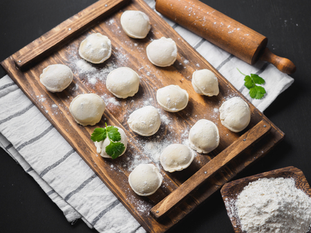 Frozen raw dumplings on the wooden desk on black background.の写真素材