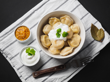 Dumplings on plate at wooden desk on black background.の写真素材