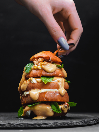 Sliced baked pear with peanut butter on black background.