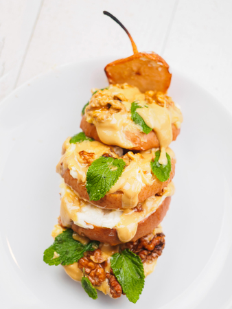 Sliced baked pear with peanut butter on white background.の写真素材