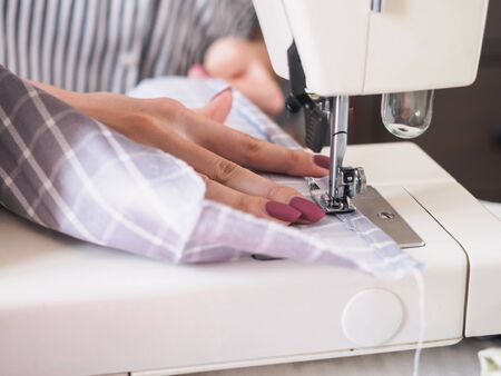 Girl working on sewing machine with textile napkins.の写真素材