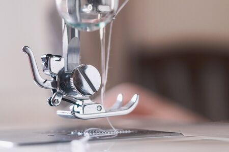 Girl working on sewing machine with textile napkins.の写真素材
