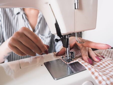 Girl working on sewing machine with textile napkins.