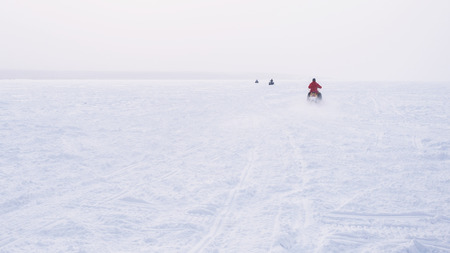 People in atv quad bike. Winter snow field.の写真素材