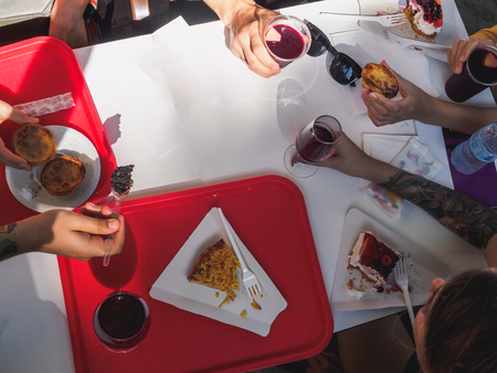 Desserts and drinks on the table. People hands top view.の写真素材