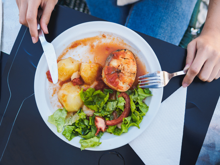 Fish and boiled potato with vegetables on the plate.の写真素材