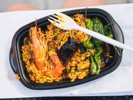 Classic paella with shrimp rice and pepper in black plastic plate.の写真素材