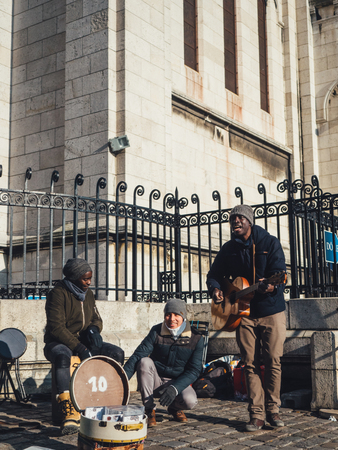 PARIS, FRANCE - JANUARY 19: street musicians near Sacre Coeur Basilica in winter day. Medieval cathedral. Basilica of Sacred Heart.のeditorial素材