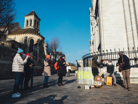 PARIS, FRANCE - JANUARY 19: street musicians near Sacre Coeur Basilica in winter day. Medieval cathedral. Basilica of Sacred Heart.のeditorial素材