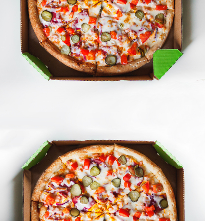 Cheeseburger pizza in delivery cardboard box on white table.の写真素材
