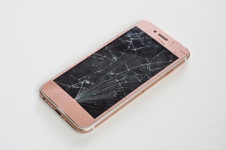 Broken glass screen rose smartphone in hand, white background.の写真素材