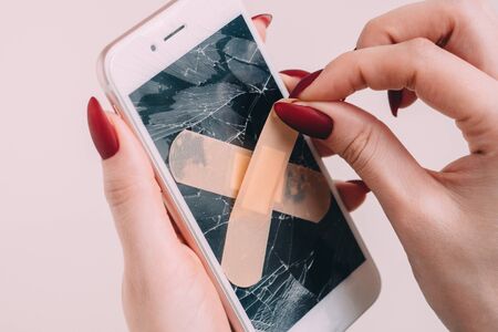 Broken screen with plaster of white smartphone. white backgroundの写真素材