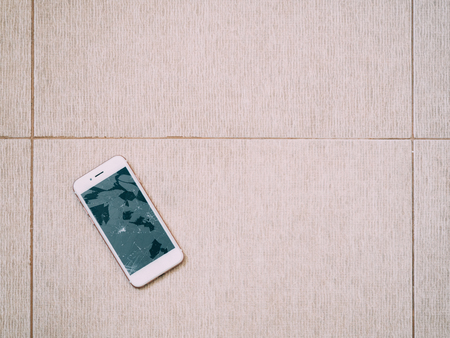 Broken screen smartphone on the floor tile.の写真素材