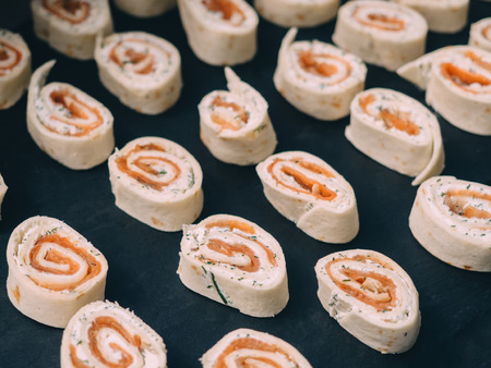 Rolls of thin pancakes with smoked salmon, horseradish cream cheese.