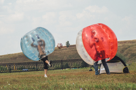 People play bumperball zorbsoccer outdoor. summer time.の写真素材