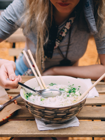 Vietnamese cuisine soup Pho Ga with chicken, noodles, fresh herbs and sauce in a bowl.の写真素材