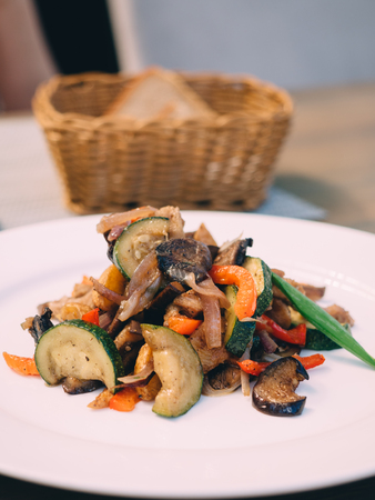 Pork roast with vegetables on white plate in table.の写真素材