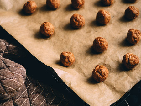 Hot prepared meat balls on baking sheet with paper.