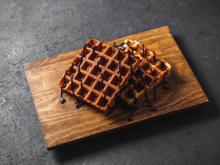 Belgian waffles with chocolate on wooden board.の写真素材