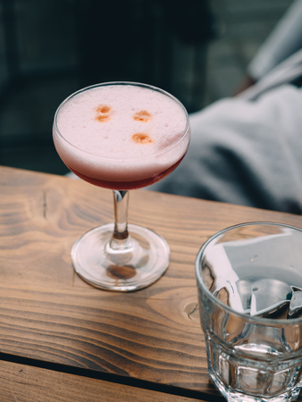 Red alcohol cocktail in glass with ice.