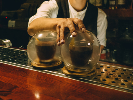 Bartender making cocktail with pinecone in bar restaurant.の写真素材