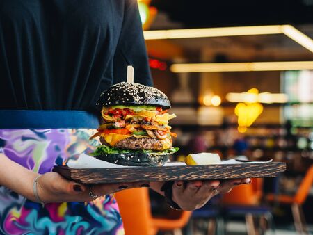 Big burger with beef cutlet, black bun and mushrooms.の写真素材