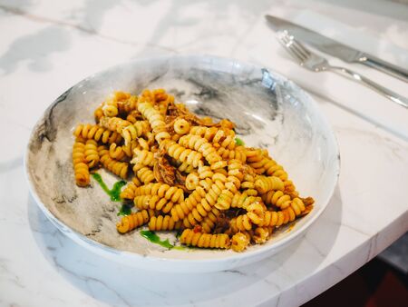 Fusilli pasta with meat on the marble table in bistro.の写真素材