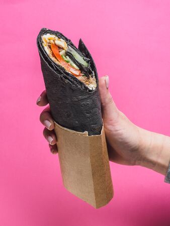 Shawarma roll with black pita on pinkの写真素材