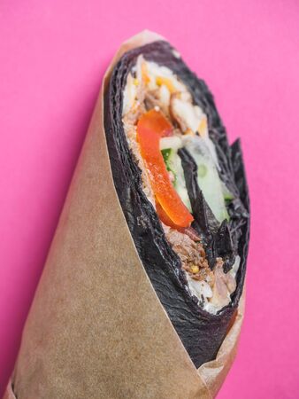Shawarma roll with black pita on pinkの写真素材