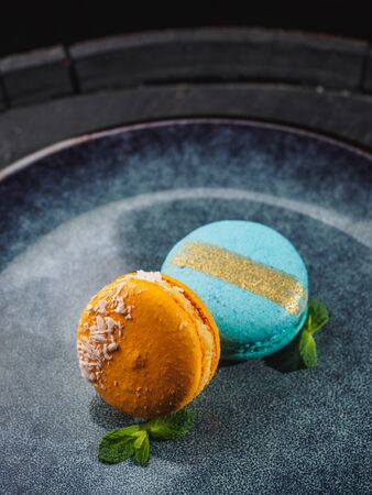 Color macaroons with mint on the blue plate.の写真素材