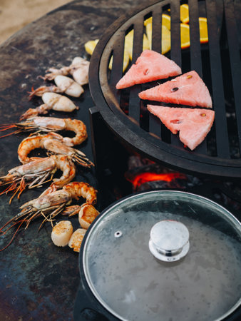 Cooking of seafood prawn squid on metal grill bbq.