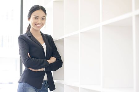 Businesswoman cross one's arm,Professional woman is smiling in black suite.の写真素材