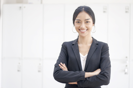 Businesswoman cross one's arm,Professional woman is smiling in black suite.の写真素材
