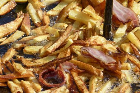 Fries soaked in oil with some baconの写真素材