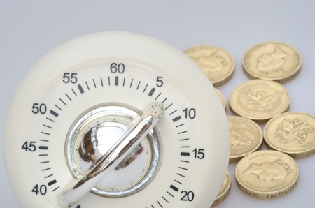 Timer in close up with group of pound  coinsの写真素材