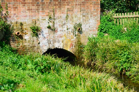 Red brick bridge over small streamの写真素材