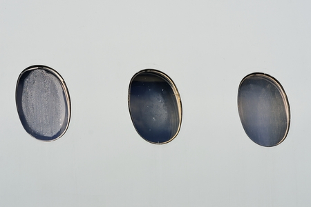 Port holes on aircraft cabinの写真素材