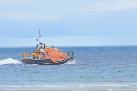 Sennen Cove Cornwall , United Kingdom - July 02, 2016:  RNLI lifeboat heading out to seaのeditorial素材